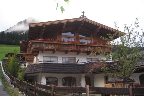 Wohnhaus mit Balkon und Fassade aus Altholz